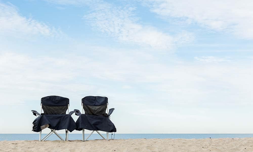 Two beach chairs on the beach of Pacific Ocean.